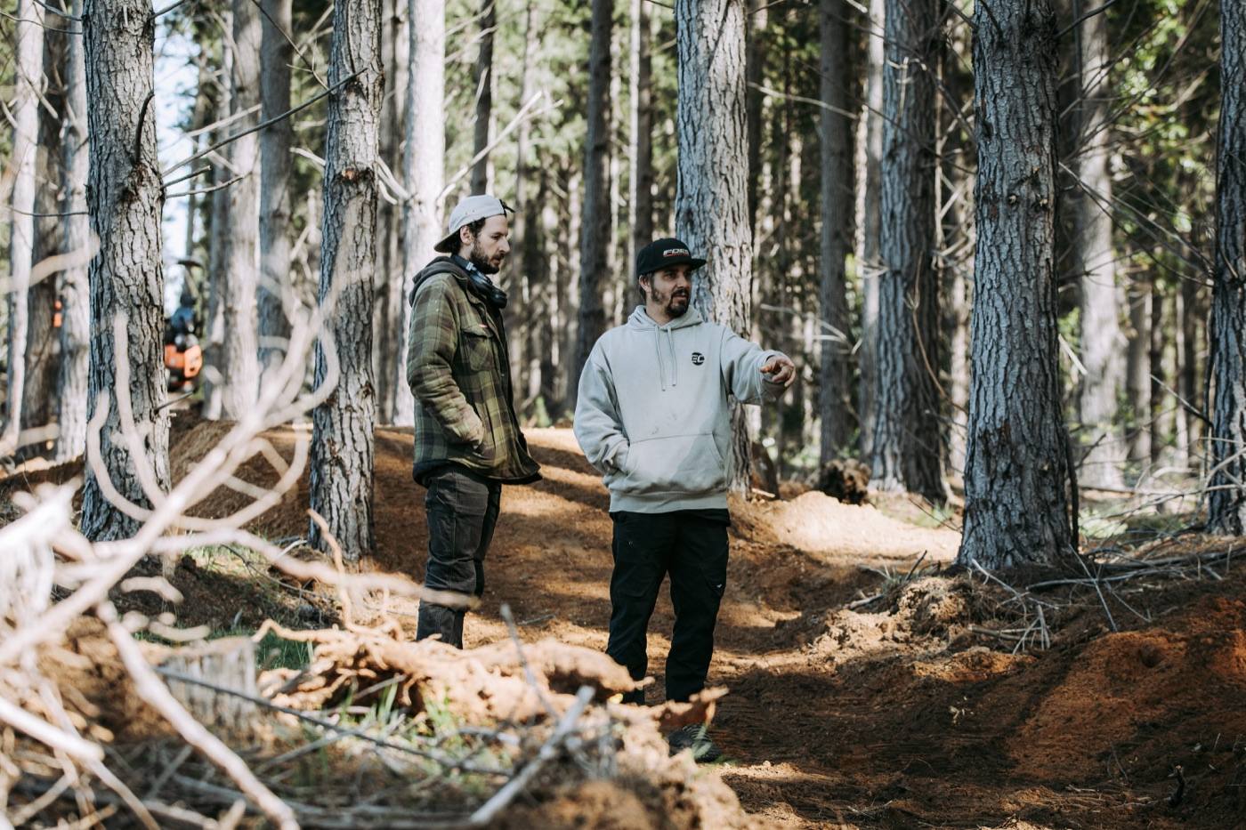 Sam Hill Signature Trail team on site, consulting on a trail through pine forest