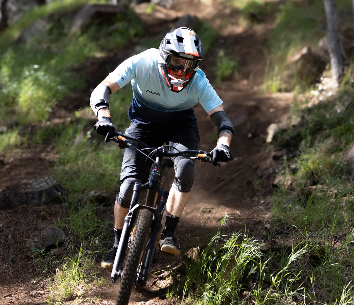 Lukas Baker riding a trail through the pine forest